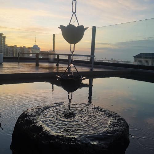 a statue of a flower in the water at Xueershanfang · Shanhaijing in Sanya