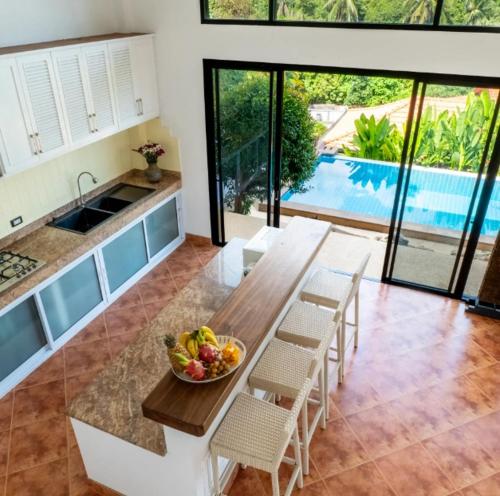 a kitchen with a table with a bowl of fruit on it at V196 Sea View 3BR, Infinity Pool and Open Living in Ban Ko Khwan