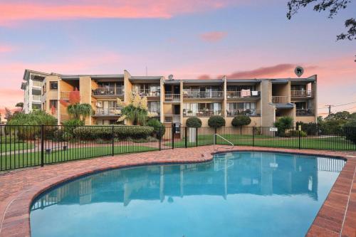 an image of a apartment complex with a swimming pool at Two bedroom river view unit with pool in Maroochydore