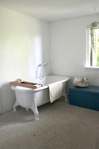 a white bath tub in a room with a window at Guest house Æbelnæs, Møn in Stege
