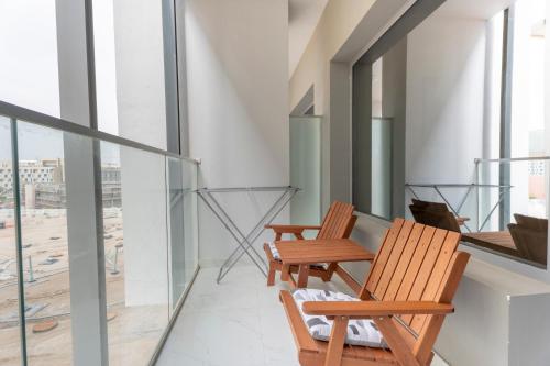 two chairs sitting on a balcony with windows at Stunning Oasis 1 Studio Masdar City in Abu Dhabi