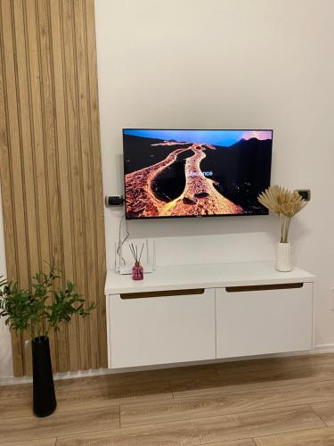 a flat screen tv sitting on top of a white entertainment center at Riara Home in Vlorë