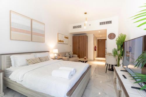 a bedroom with a large bed and a living room at Stunning Oasis 1 Studio Masdar City in Abu Dhabi