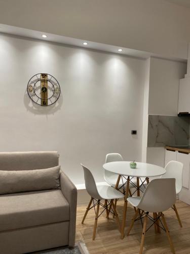 a living room with a couch and a table and chairs at Riara Home in Vlorë