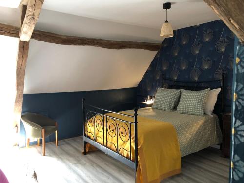 Bramble cottage في Saint-Didier-en-Donjon: غرفة نوم بها سرير وجدار أزرق