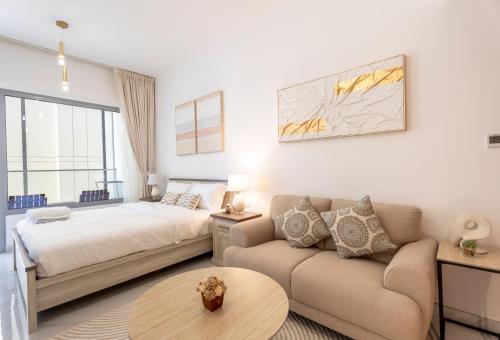 a bedroom with a bed and a couch at Stunning Oasis 1 Studio Masdar City in Abu Dhabi