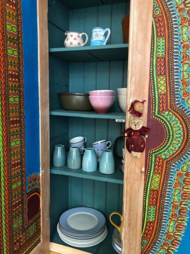 Bramble cottage في Saint-Didier-en-Donjon: خزانة مليئة بالأطباق والأطباق