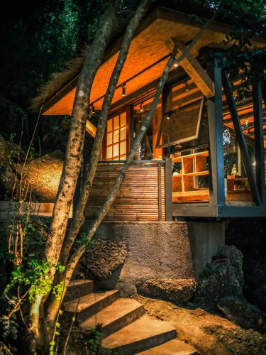 a log cabin with stairs leading up to it at Xueershanfang · Shanhaijing in Sanya