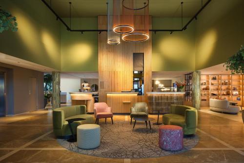 a lobby with chairs and tables and a library at Hilton Garden Inn Leiden in Leiden
