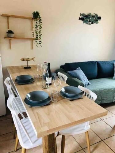 une table en bois avec des assiettes et des verres à vin dessus dans l'établissement La maison aux galets, à Talmont-Saint-Hilaire