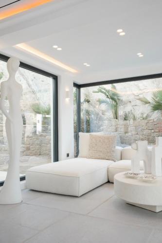 biały salon z białą kanapą i oknem w obiekcie Villa Matrix w mieście Mykonos