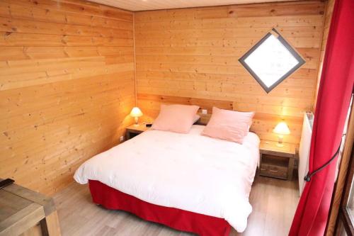 une chambre avec un lit dans une pièce en bois dans l'établissement Residence Le 1650 - Appartement pour 6 personnes cœur de station des Orres 1650 MAE-6283, aux Orres