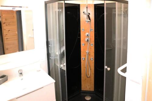 La salle de bains est pourvue d'une douche et d'une porte en bois. dans l'établissement Residence Le 1650 - Appartement pour 6 personnes cœur de station des Orres 1650 MAE-6283, aux Orres