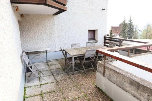 un patio avec une table et des chaises sur un balcon dans l'établissement Residence Le 1650 - Appartement pour 6 personnes cœur de station des Orres 1650 MAE-6283, aux Orres