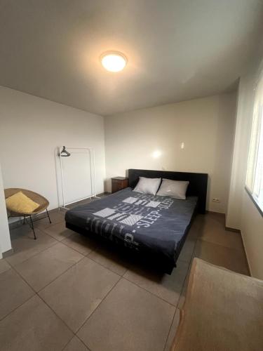 Un dormitorio con una cama y una silla dentro. en Modern apartment, en Maaseik