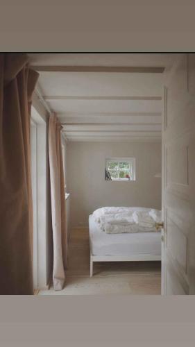a bedroom with a white bed and a window at Peace In Beautifully Renovated Country House in Ålsgårde