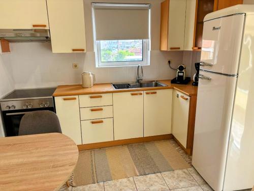 a kitchen with a white refrigerator and a sink at Casa Dio in Preveza