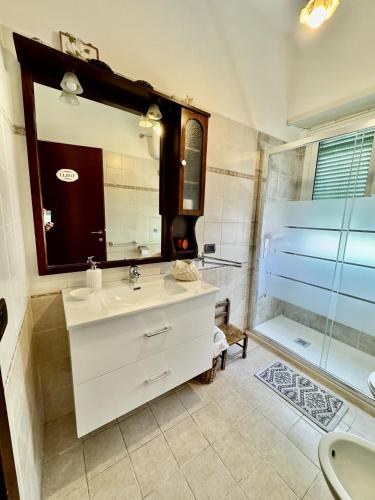 a bathroom with a white sink and a shower at Appartamento sul porto Nettuno in Nettuno