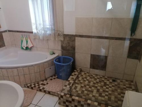 a bathroom with a tub and a toilet and a sink at Marinda's in Hibberdene