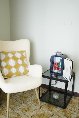 a white chair and a table with a tv at Una finestra sulla Reggia in Caserta