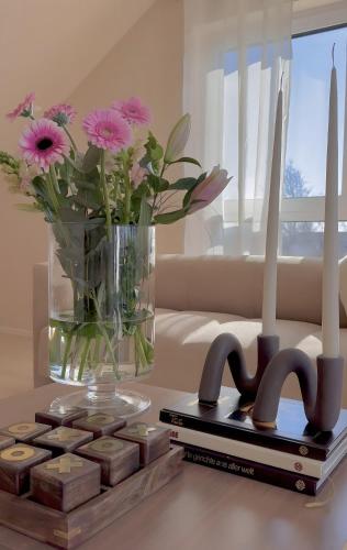 a table with a vase of flowers and a book at Michou Apartment in Grafenhausen