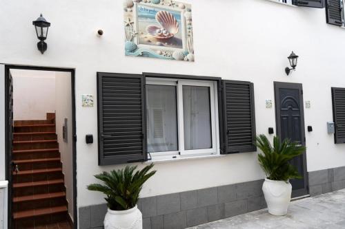 una casa con persianas negras y una ventana en Le Tre Perle Ischia, en Isquia