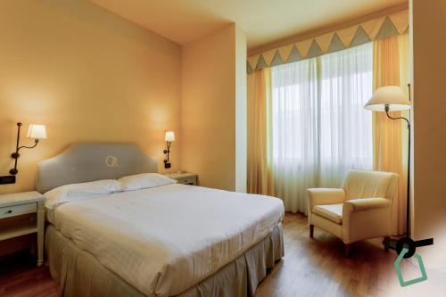 a hotel room with a bed and a chair and a window at HOTIDAY Room Collection - Calambrone in Tirrenia