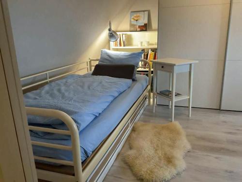 a bed in a room with a night stand and a table at Family House Near Beach With Garden in Sarup