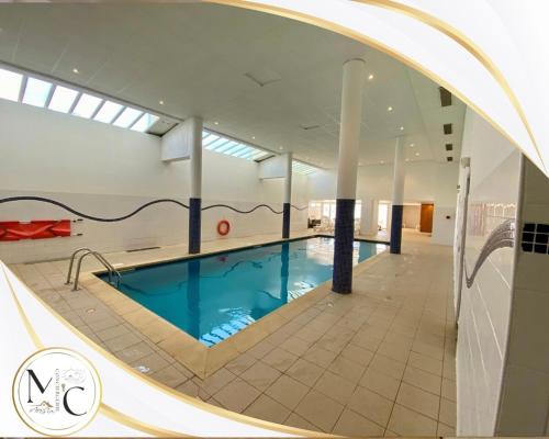 une grande piscine dans un immeuble avec une grande fenêtre dans l'établissement Ski apartment pool hammam, à Allos