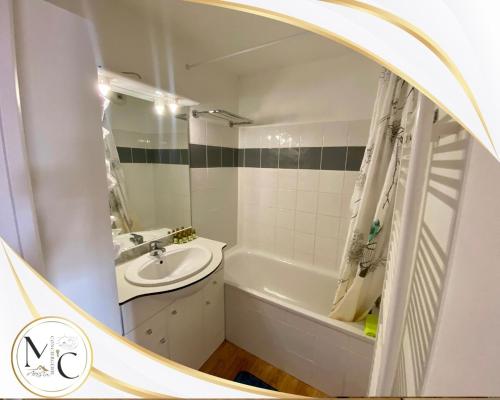 une salle de bain avec une baignoire, un lavabo et un miroir dans l'établissement Ski apartment pool hammam, à Allos