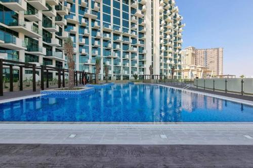 a large blue swimming pool in front of a building at Studio Free Parking Pet Friendly Near Downtown Dubai in Dubai
