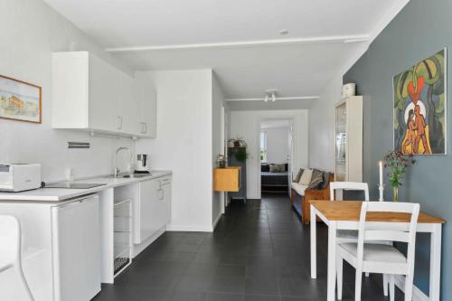 a kitchen with white cabinets and a table and chairs at Holiday Home With Private Beach And Sea View in Køge