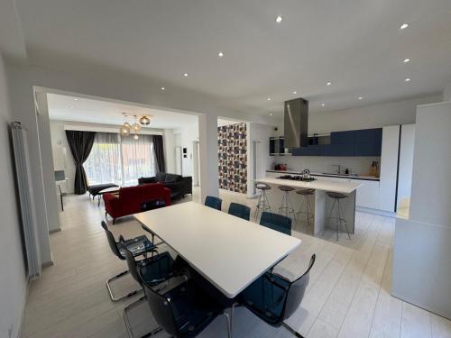a kitchen and living room with a white table and chairs at Casa vacanza Tolda in Lido di Ostia