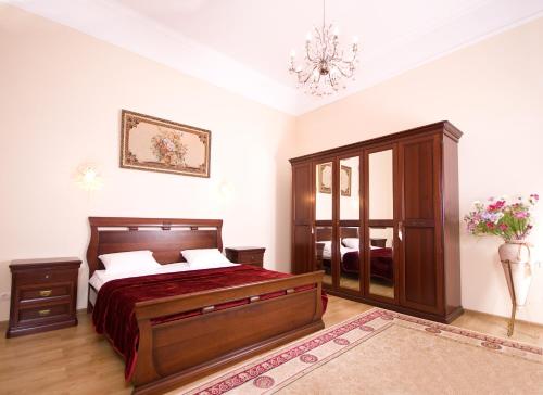 a bedroom with a bed and a dresser and a mirror at Ekaterina Hotel in Odesa