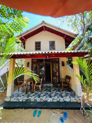 a house with a table and chairs in front of it at Vinka Place Arugambay in Arugam Bay