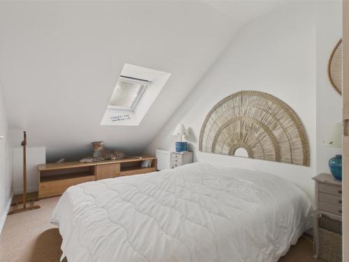 a bedroom with a white bed and a window at 400m de la plage, jardin, maison pour 5 in Kermoisan