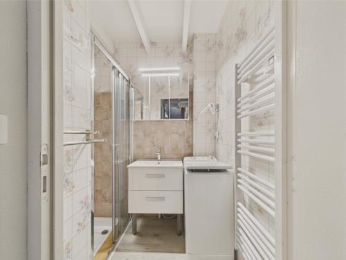 a white bathroom with a sink and a shower at 400m de la plage, jardin, maison pour 5 in Kermoisan