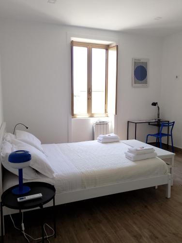 a bedroom with a white bed with a blue chair at Almarisa - appartamento vista mare in Salerno