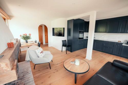 a living room with a couch and a table at Stylish Lakeview Apartment Balcony & Free Parking in Laax