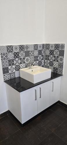 a bathroom with a sink and black and white tiles at Fortune Retreats in Ooty