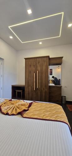 a bedroom with a large bed and a dresser at Fortune Retreats in Ooty