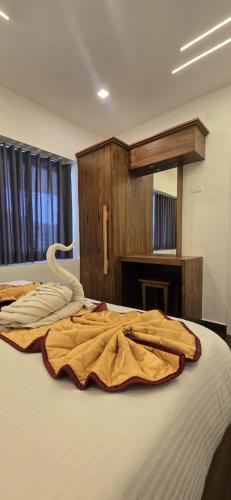 a bed with a swan laying on top of it at Fortune Retreats in Ooty