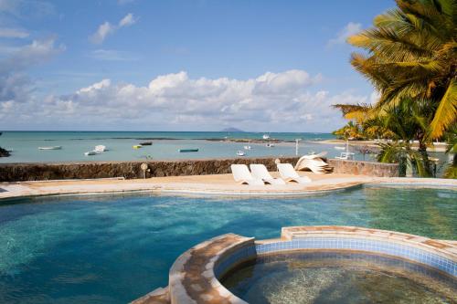 a swimming pool with a view of the ocean at Villas Banyan in Grande Gaube