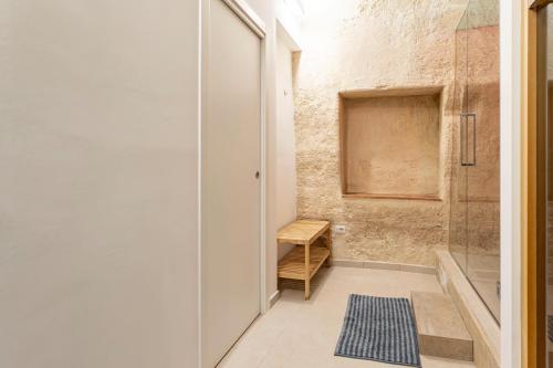 baño con ducha a ras de suelo junto a una puerta de cristal en GuestHost - White Stones Rooms, en Matera