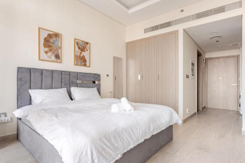 a bedroom with a large bed with white sheets at Studio Free Parking Pet Friendly Near Downtown Dubai in Dubai