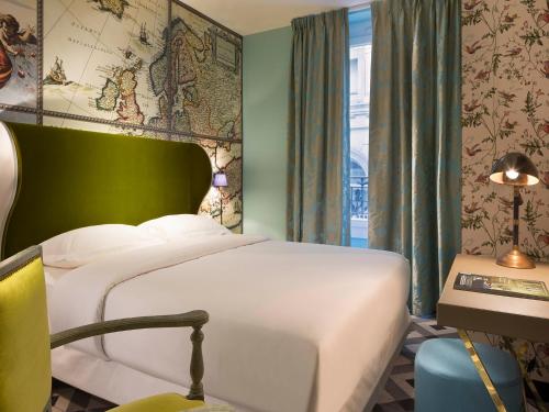 a bedroom with a white bed and a green wall at Hôtel du Continent in Paris