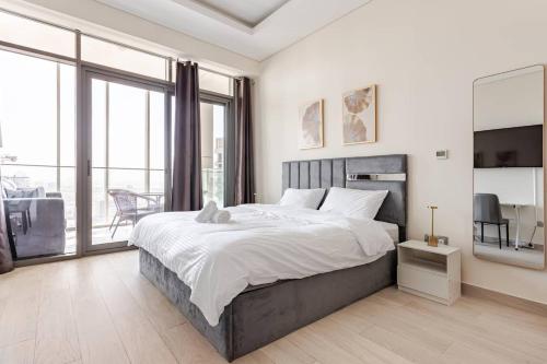a bedroom with a large bed and large windows at Studio Free Parking Pet Friendly Near Downtown Dubai in Dubai