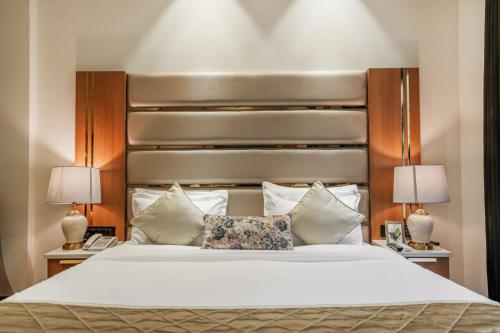 a bedroom with a large white bed with two lamps at Levelup Plus Near Goal Bagh Railway Station Amritsar in Amritsar