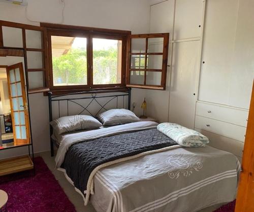 a bedroom with a bed with two pillows and a window at Private house near Amarynthos, Evia, Greece in Amarinthos