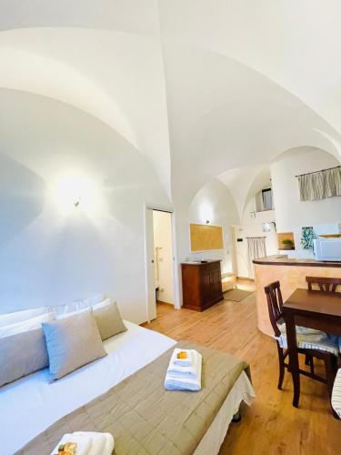 a room with a bed and a table and a kitchen at Casa Leon in Sperlonga
